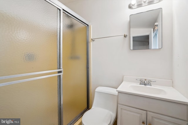 bathroom featuring a stall shower, vanity, and toilet