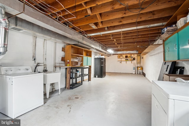 unfinished basement with freestanding refrigerator