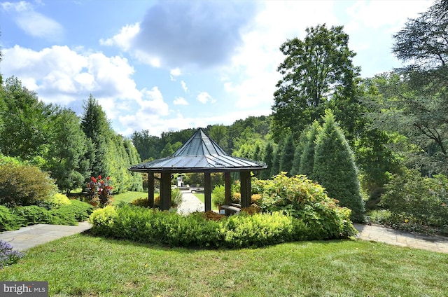 view of home's community with a forest view, a lawn, and a gazebo