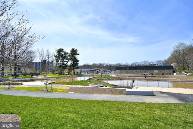 surrounding community with a lawn and a water view