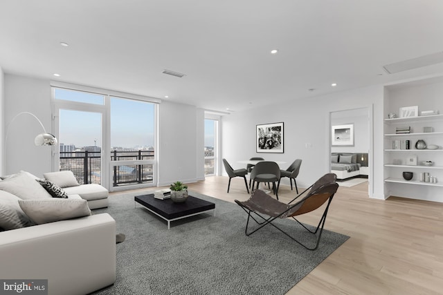 living room featuring light wood-type flooring and expansive windows