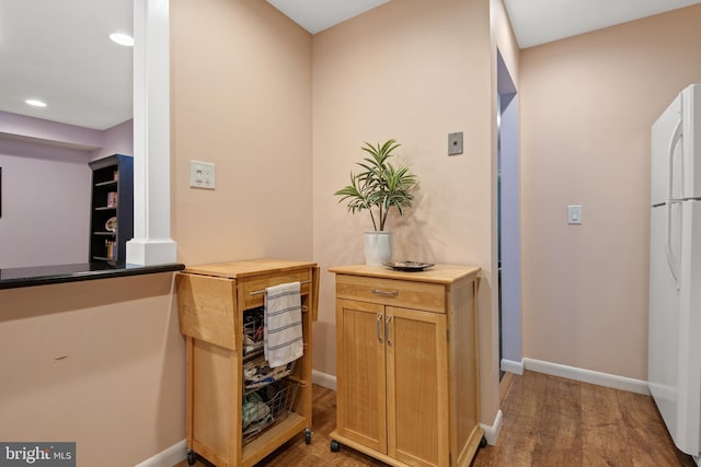 interior space with recessed lighting, baseboards, wood finished floors, and freestanding refrigerator