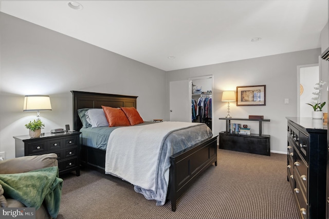 carpeted bedroom with baseboards, a walk in closet, and a closet