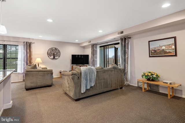 carpeted living room featuring visible vents, baseboards, a wealth of natural light, and recessed lighting