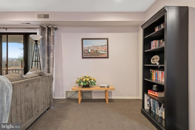 sitting room featuring baseboards, visible vents, and dark carpet