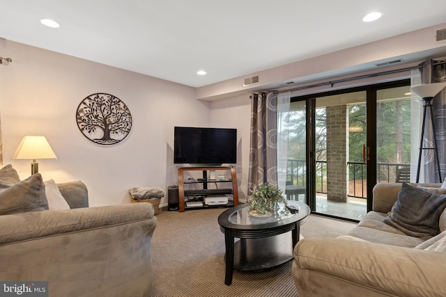 carpeted living area with visible vents and recessed lighting