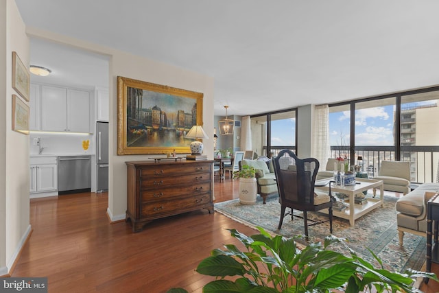 living area featuring dark wood-style floors, expansive windows, and baseboards