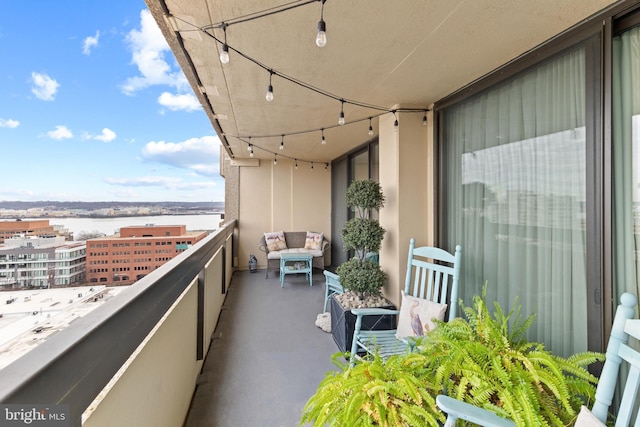 balcony featuring a sunroom and a water view