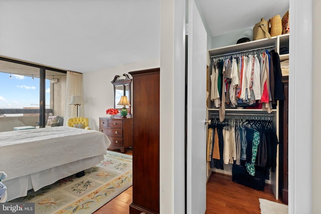 bedroom featuring a closet, multiple windows, and wood finished floors