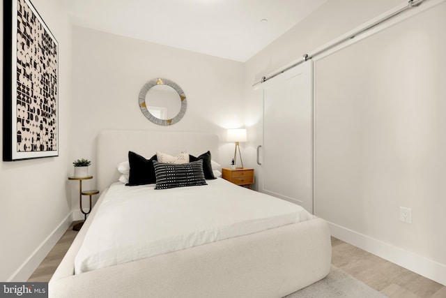 bedroom featuring light hardwood / wood-style floors and a barn door