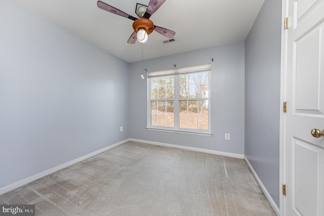 empty room featuring light colored carpet, visible vents, baseboards, and a ceiling fan