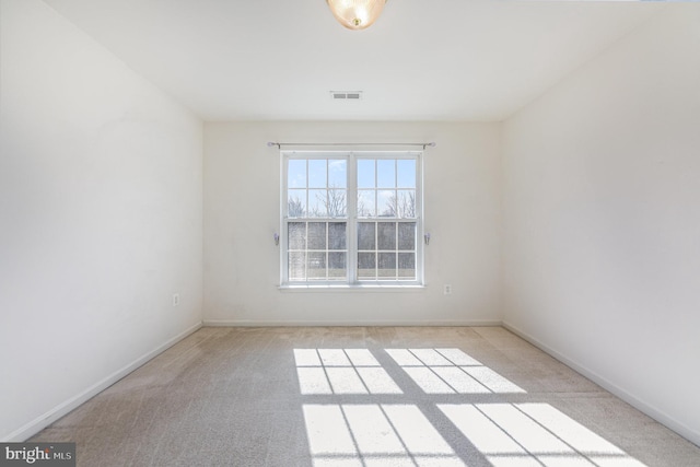 spare room with baseboards, visible vents, and carpet floors