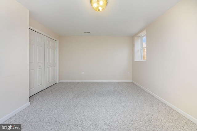unfurnished bedroom featuring baseboards, visible vents, a closet, and carpet floors