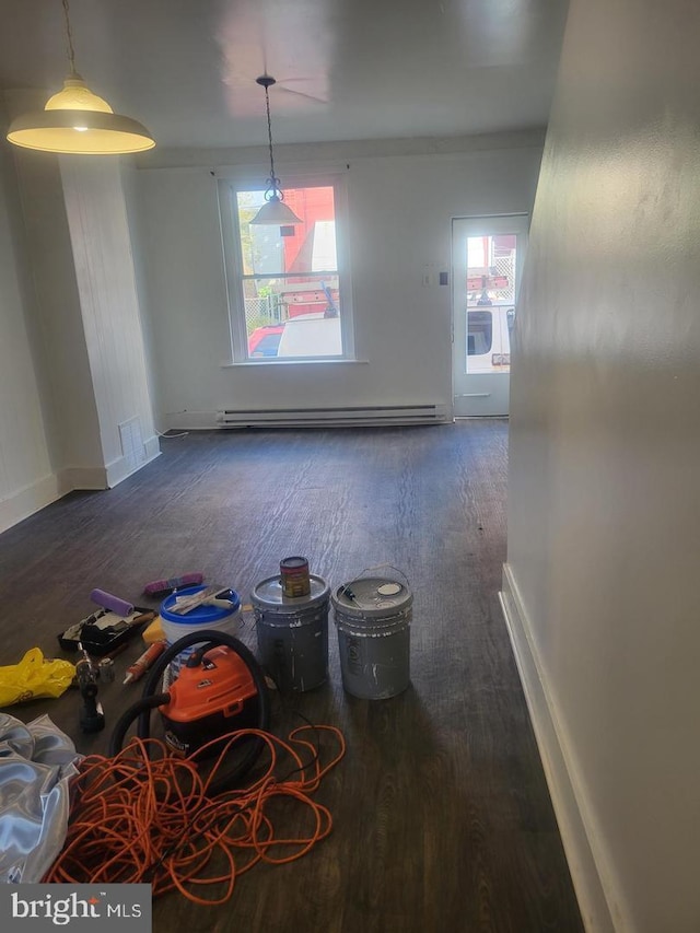 unfurnished dining area featuring dark hardwood / wood-style flooring and a baseboard heating unit