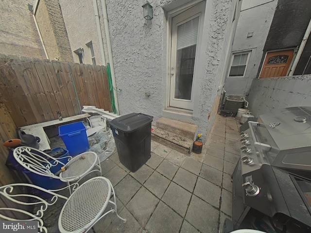 view of patio / terrace with entry steps, fence, grilling area, and cooling unit