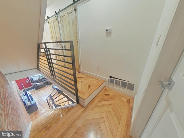 staircase featuring a barn door and visible vents