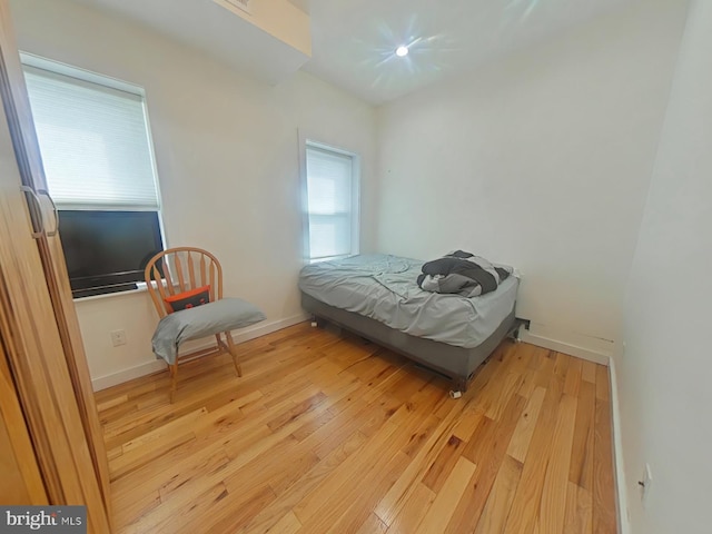 bedroom with light wood-style floors and baseboards