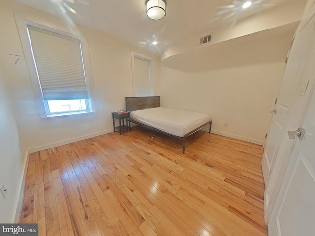 unfurnished bedroom featuring light wood finished floors, baseboards, and visible vents