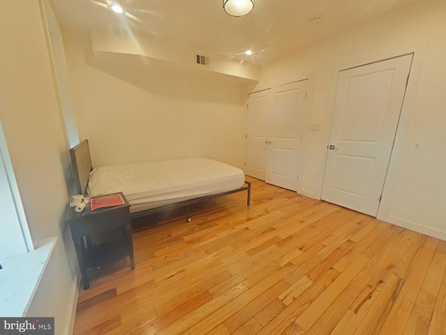 bedroom with light wood-style flooring and visible vents