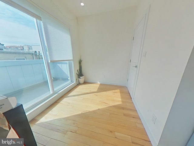 hallway with light wood finished floors, plenty of natural light, recessed lighting, and baseboards