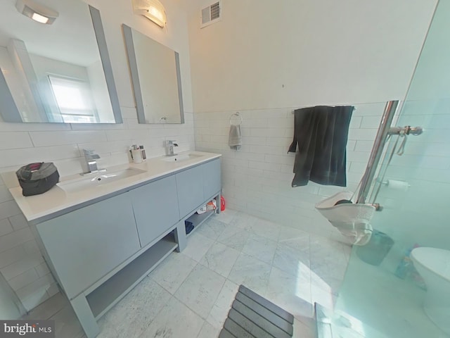 full bathroom with a stall shower, visible vents, a sink, and double vanity