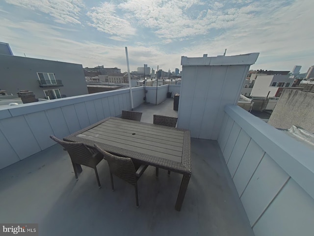 balcony featuring outdoor dining area and a city view