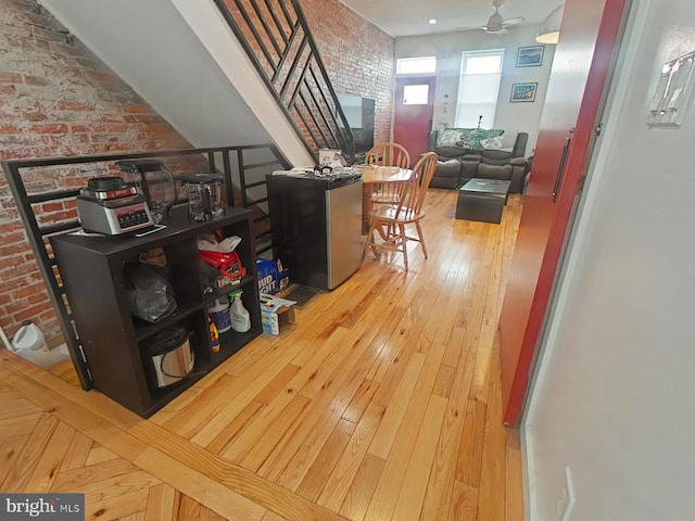 hall with brick wall and hardwood / wood-style flooring