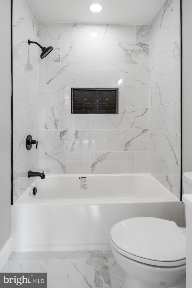 bathroom featuring marble finish floor, shower / bathing tub combination, and toilet