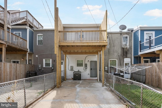 rear view of property with central AC unit, fence private yard, and stucco siding