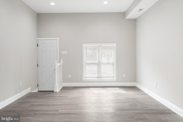 unfurnished room with baseboards, recessed lighting, and light wood-style floors