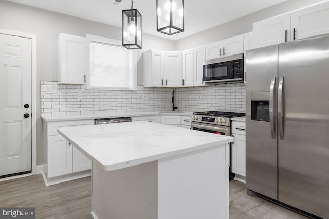 kitchen with white cabinetry, pendant lighting, stainless steel appliances, and a center island