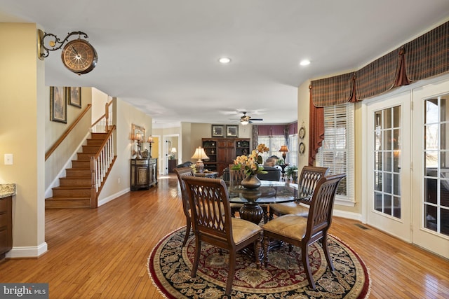 dining area with light wood-type flooring, visible vents, plenty of natural light, and stairway