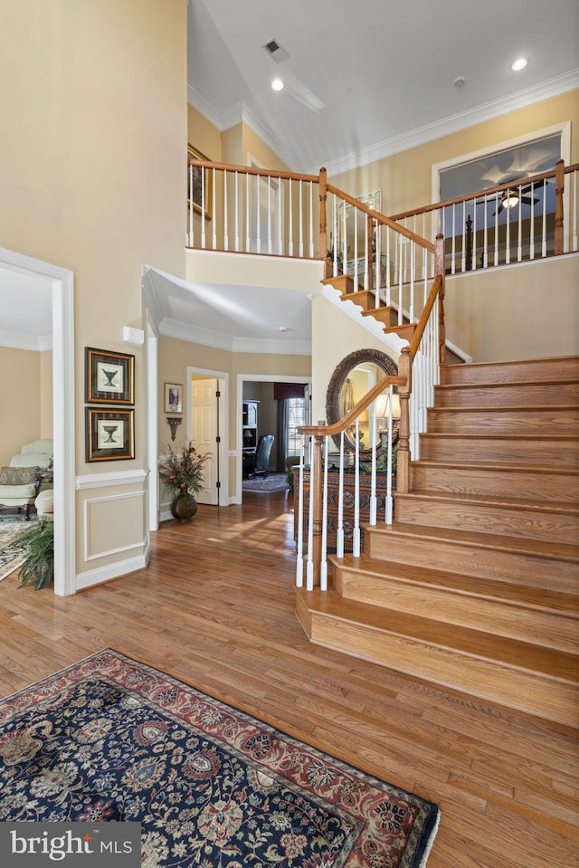 entrance foyer with a high ceiling, stairs, and ornamental molding