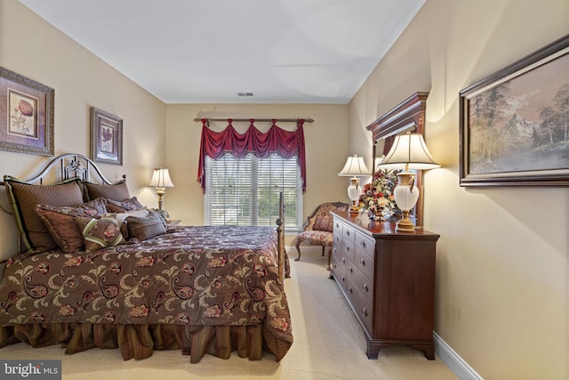 bedroom with baseboards, visible vents, and light colored carpet