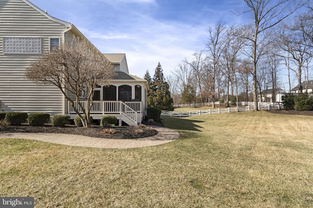 view of yard featuring a sunroom and fence