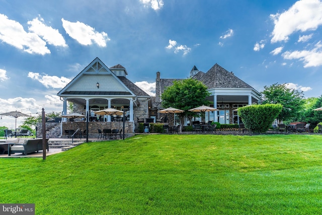 exterior space with stone siding, a lawn, and a patio