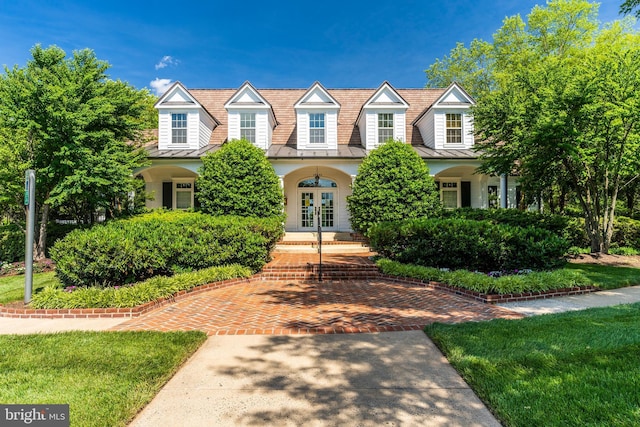 cape cod home featuring metal roof, french doors, and a standing seam roof