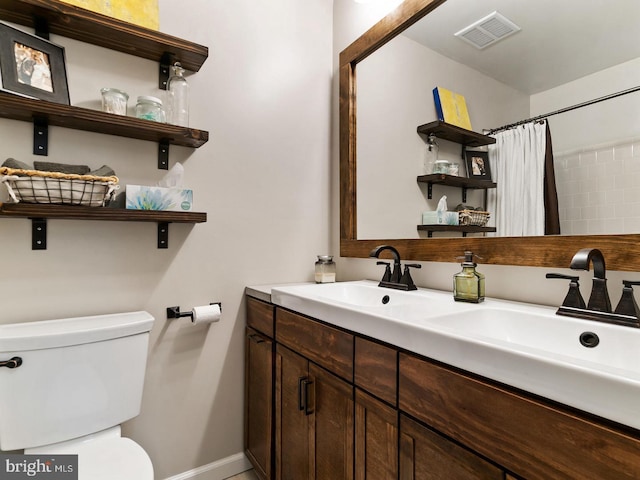 full bath featuring visible vents, baseboards, toilet, double vanity, and a sink