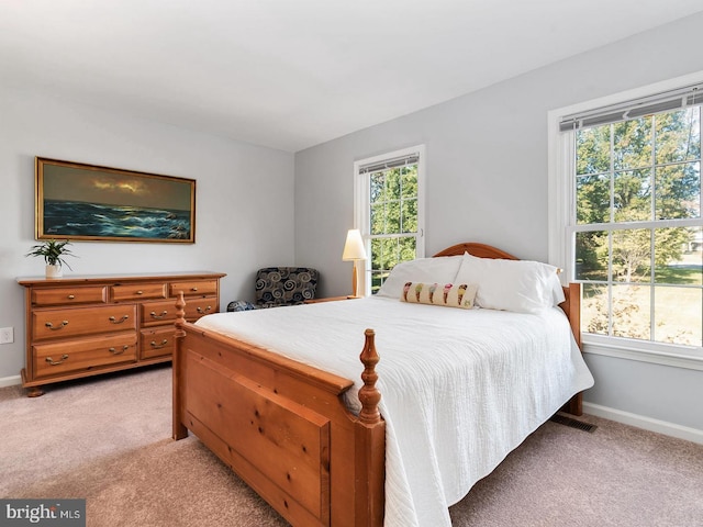 bedroom with light colored carpet and baseboards