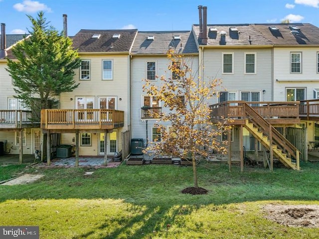 back of property featuring a deck, a patio, a yard, central AC unit, and stairs