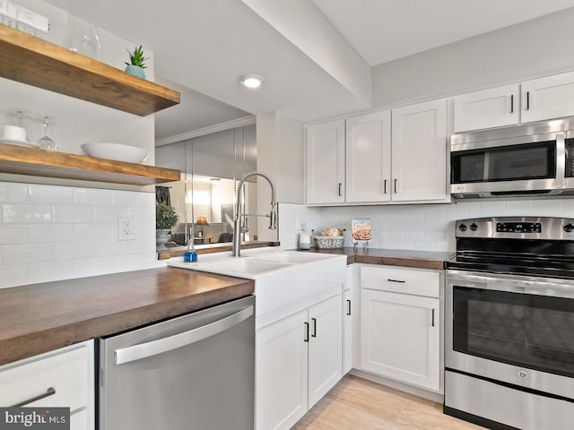 kitchen featuring open shelves, decorative backsplash, white cabinets, appliances with stainless steel finishes, and dark countertops