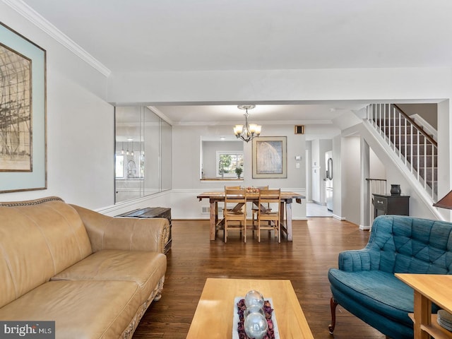 living room with dark wood finished floors, a notable chandelier, stairs, and ornamental molding