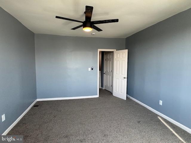 carpeted spare room featuring ceiling fan