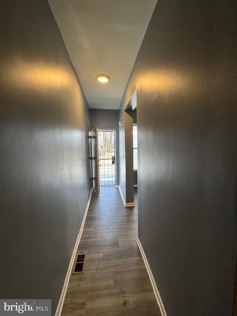 corridor with dark hardwood / wood-style flooring