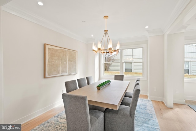 dining room featuring crown molding, baseboards, an inviting chandelier, and light wood-style floors