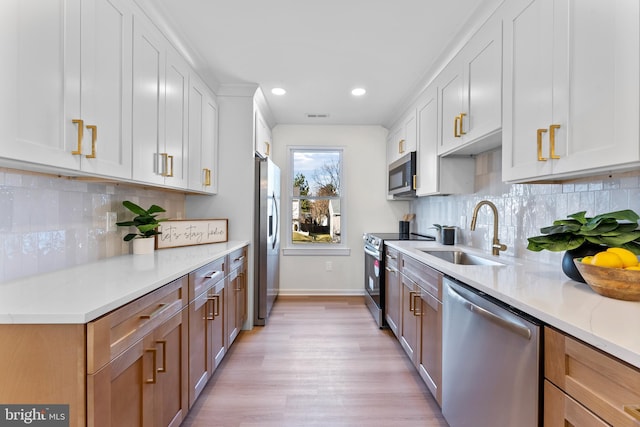 kitchen with sink, white cabinets, light stone countertops, and stainless steel appliances