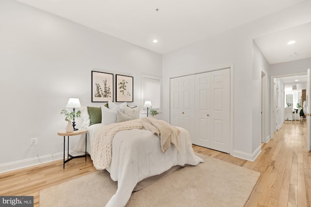 bedroom featuring recessed lighting, a closet, wood-type flooring, and baseboards