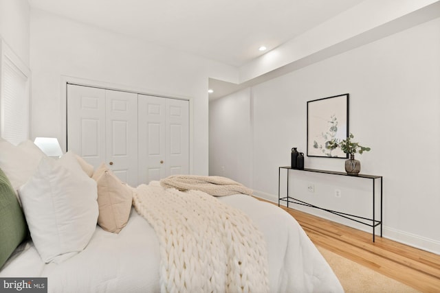 bedroom featuring a closet, baseboards, wood finished floors, and recessed lighting