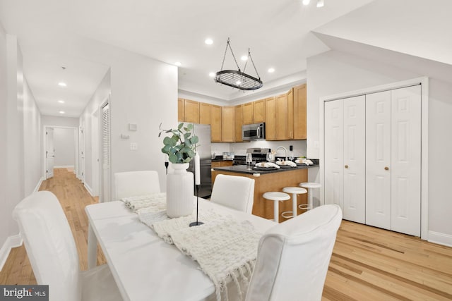 dining area with light wood-style flooring, baseboards, and recessed lighting