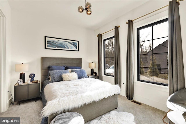 bedroom featuring light colored carpet and visible vents